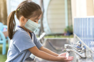 Child washing hadns in a clean bathroom