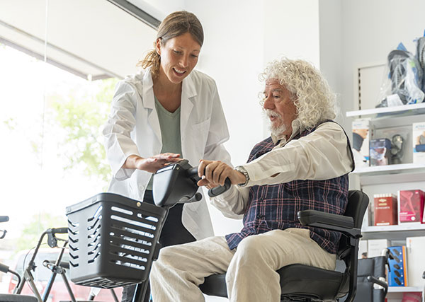 Lady helps a senior on a scooter